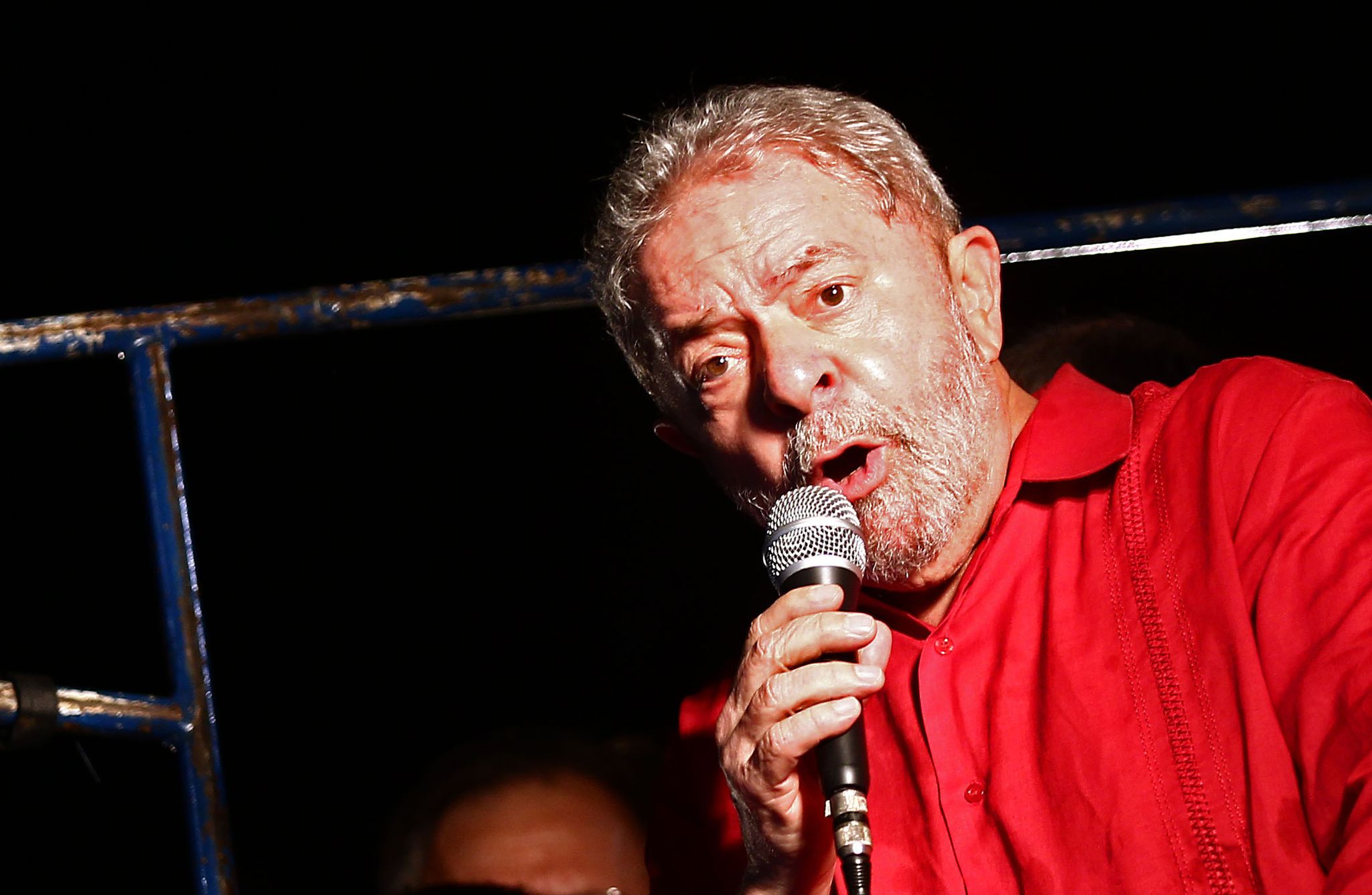 #pracegover O ex-presidente da República, Luiz Inácio Lula da Silva, discursa, segurando um microfone e usando uma camiseta vermelha, em evento contra o impeachment na Avenida Paulista