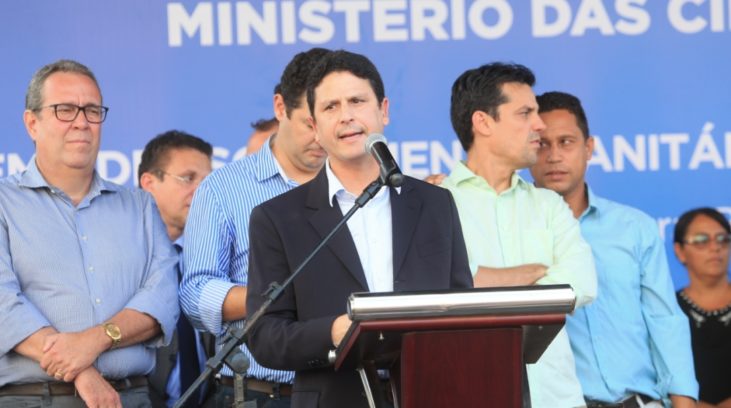 #pracegover: foto mostra ministro Bruno Araújo falando o púlpito cercado de pessoas durante cerimônia do Ministério das Cidades