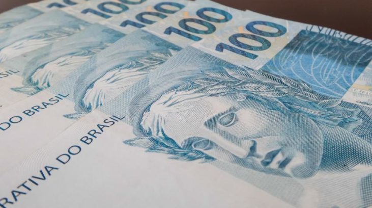 #pracegover: foto mostra cinco cédulas de R$ 100 empilhadas